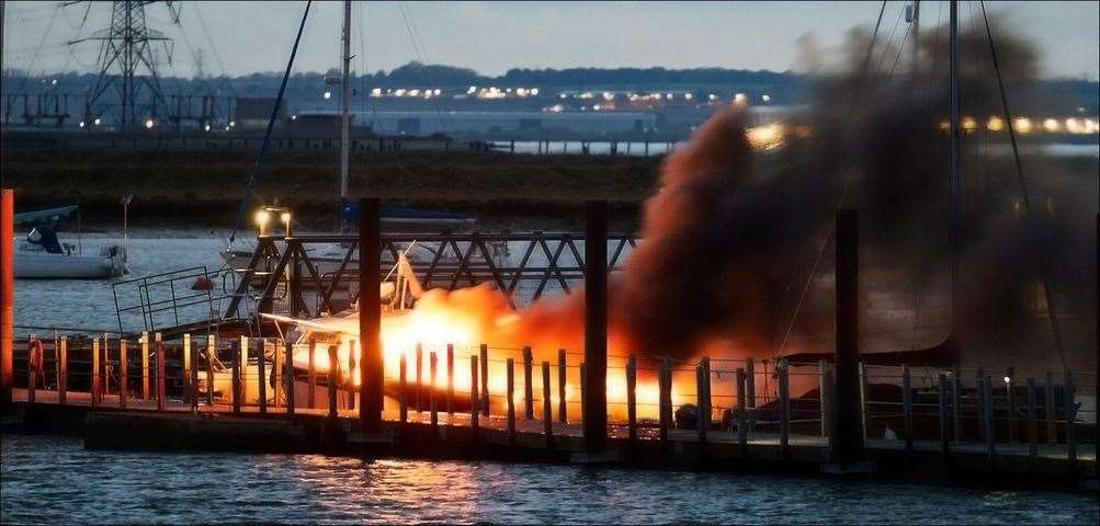 Firefighters and boat owners desperately try to put the flames out of a vessel which exploded at Queenborough marina. Picture: Henry Slack