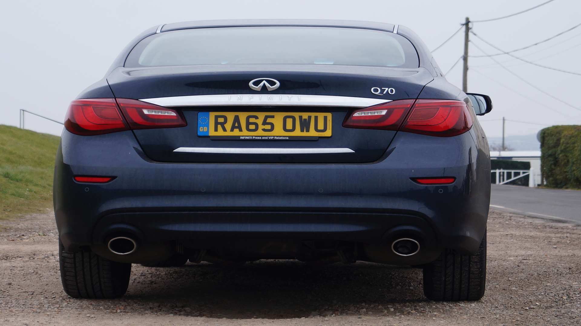 The rear is dominated by large tail light clusters joined by a broad chrome strip while under the bumper sit two fat exhaust pipes