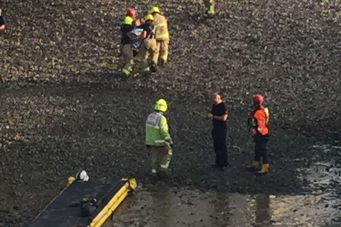 Fire crews help the woman off the beach