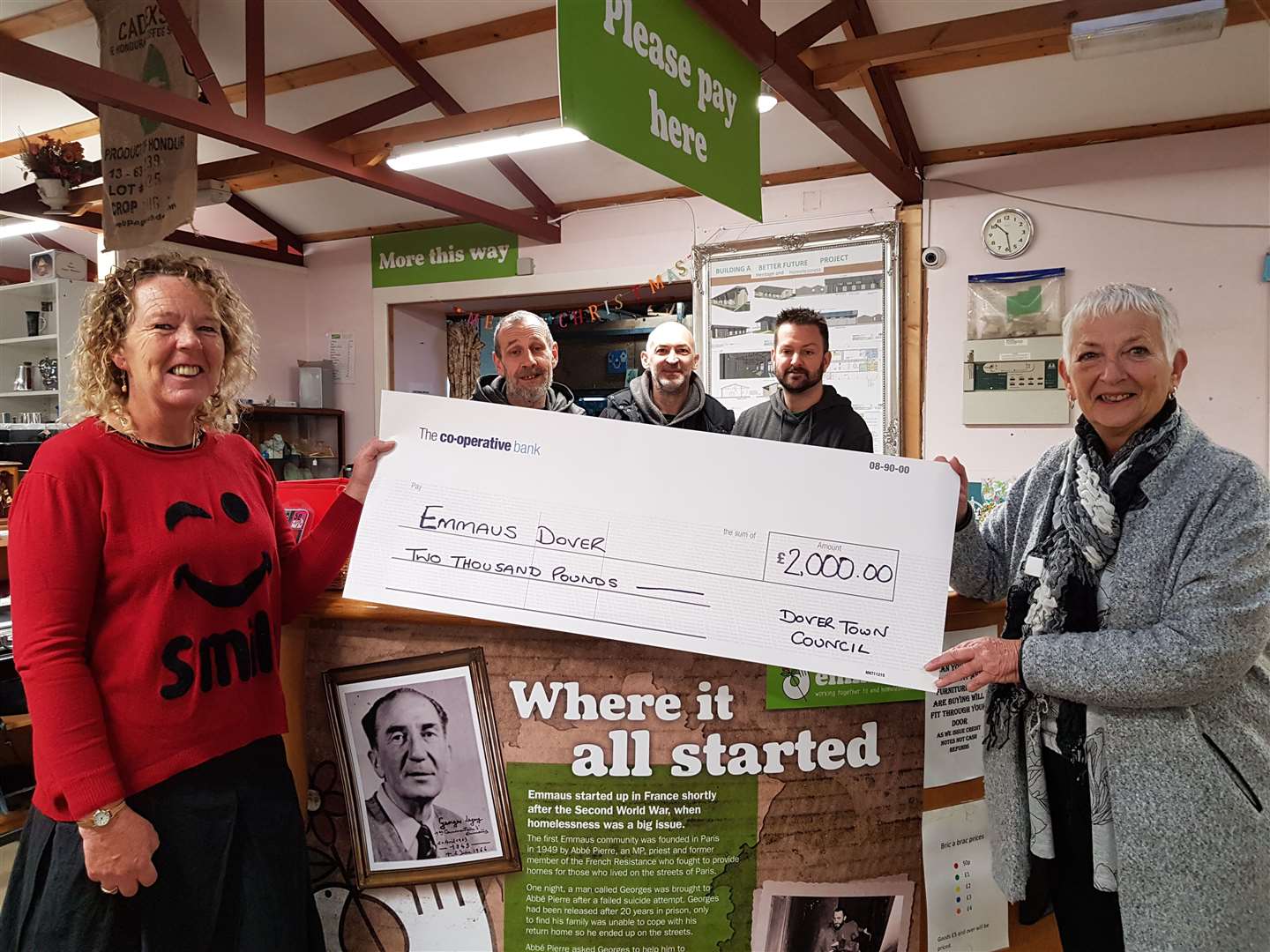 Debra Stevenson of Emmaus, receives the cheque from Cllr Cllr Pam Brivio at the charity's base. Emmaus residents are in the background. Picture: Dover Town Council