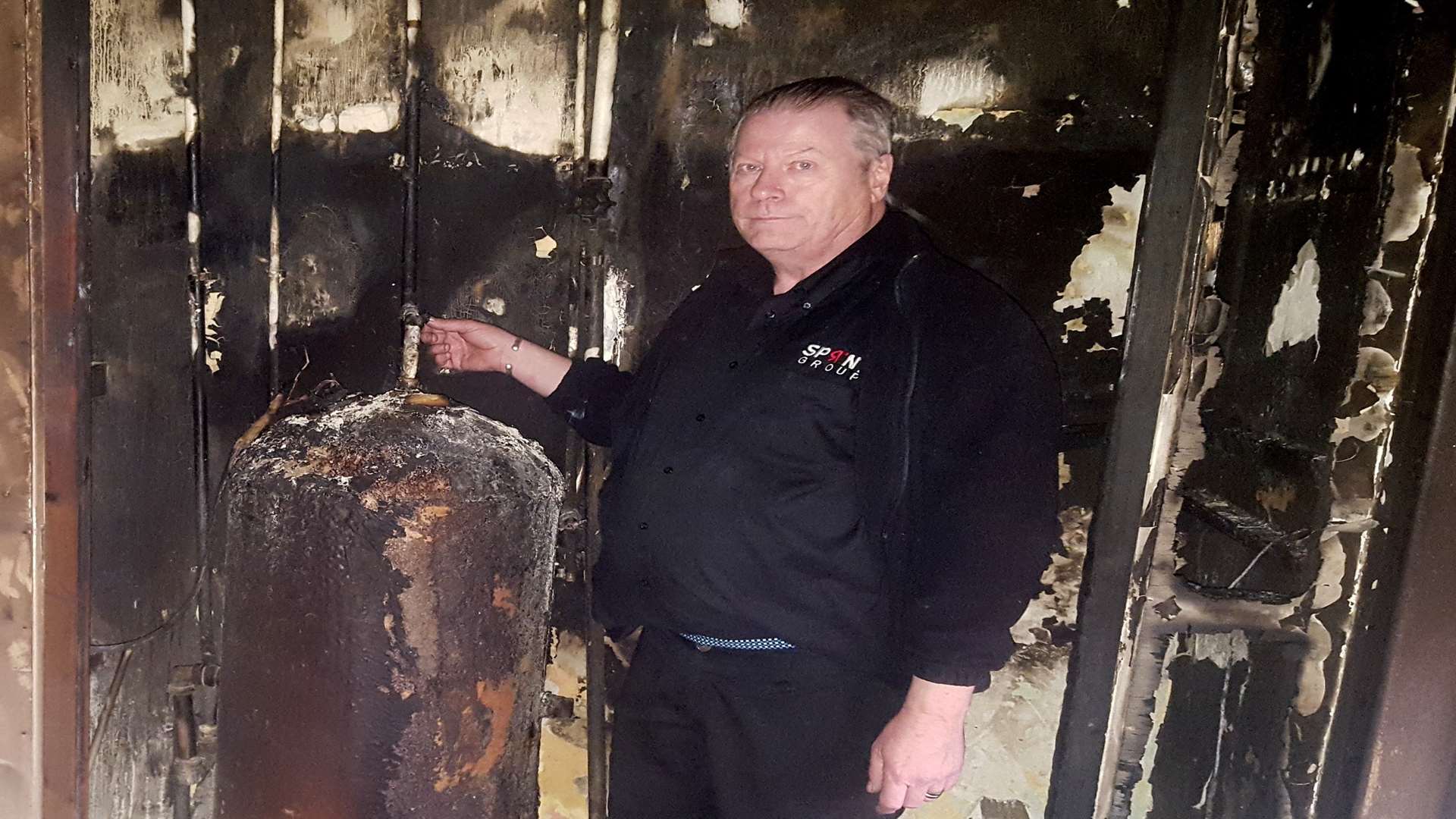 Keith Plews with the burnt airing cupboard and emersion heater where the fire is thought to have started