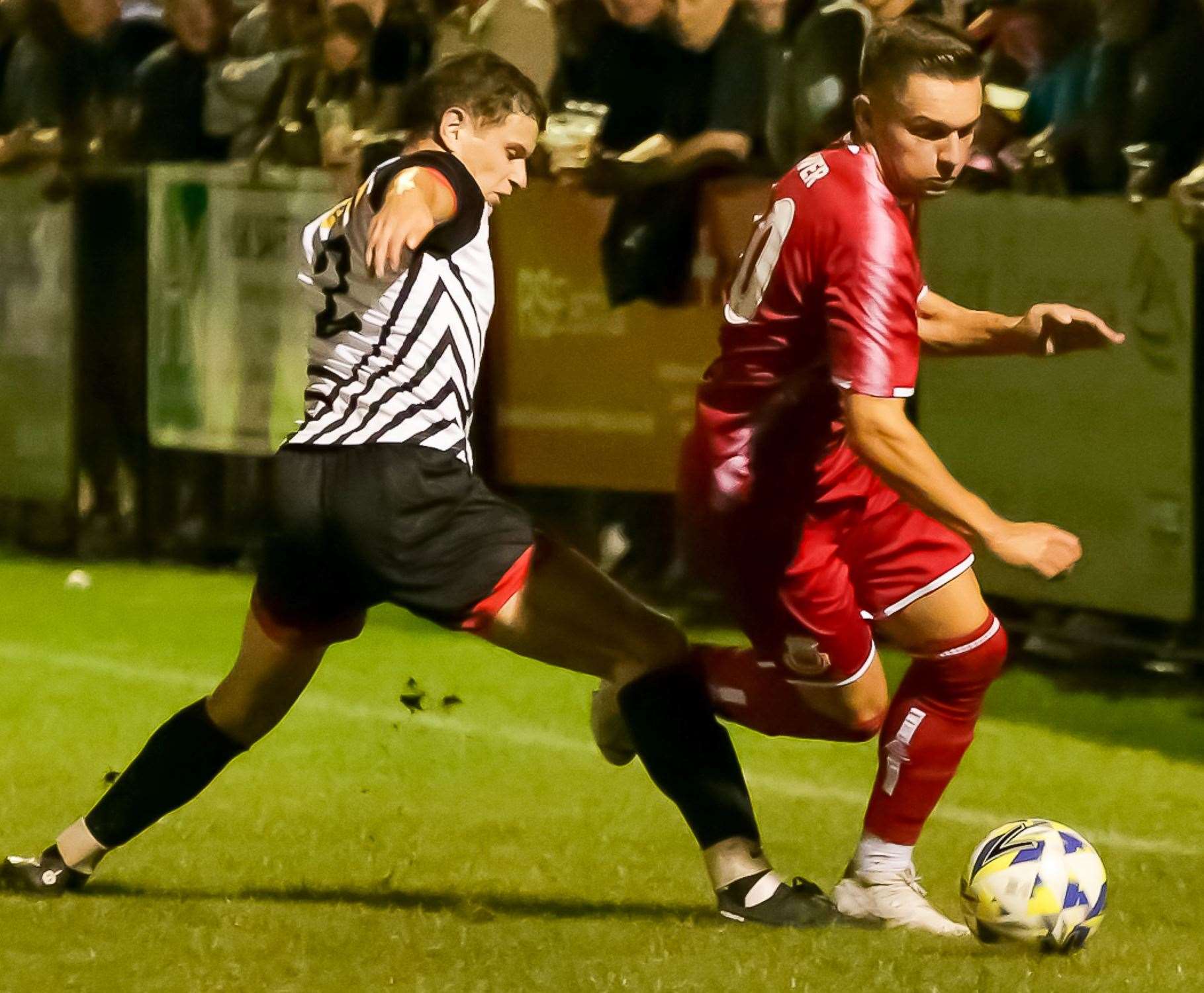 Josh Oliver of Whitstable is challenged on the wing by a Deal player in Tuesday’s 3-0 loss at the Charles Sports Ground. Picture: Les Biggs