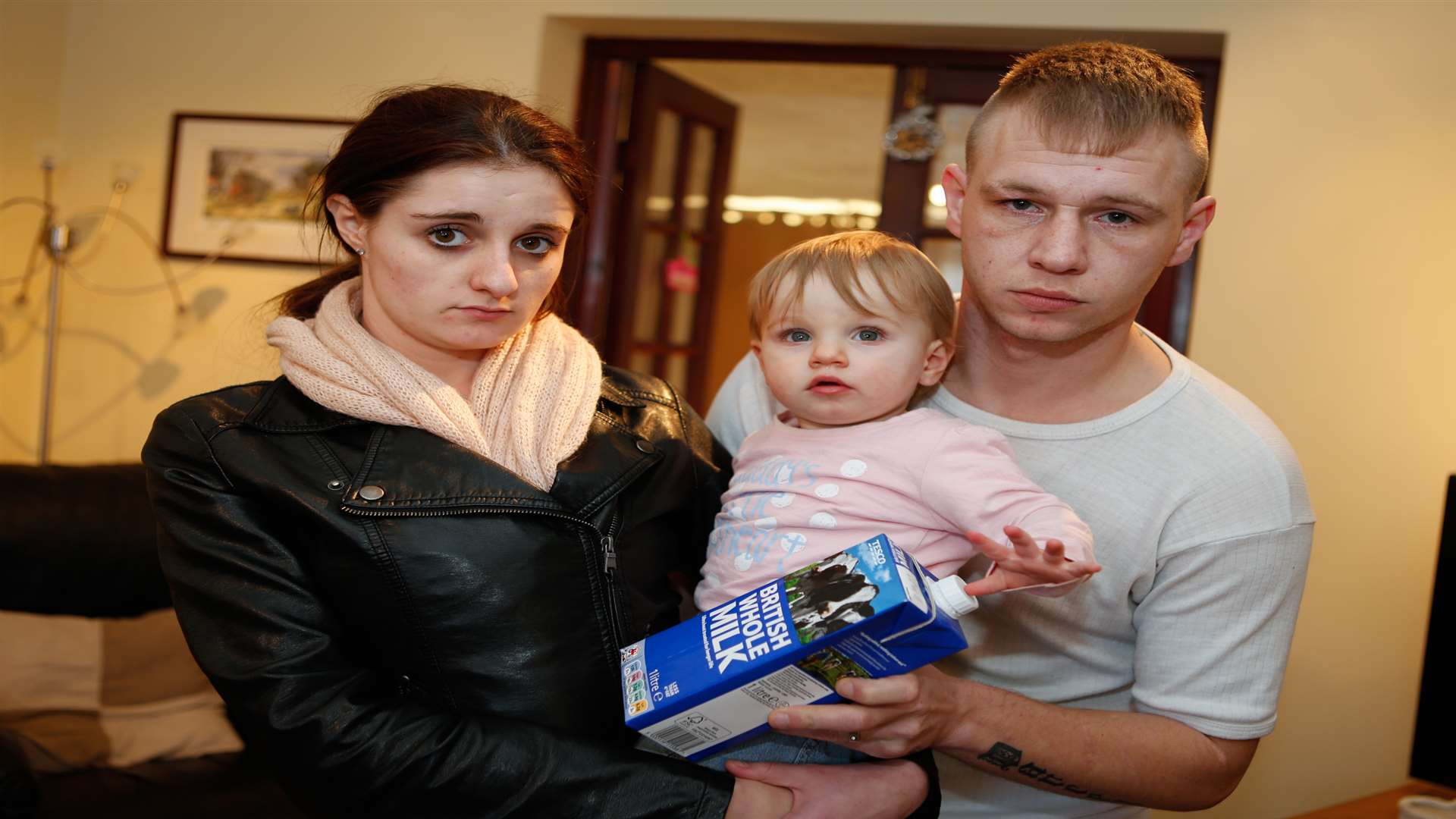 Gemma King and partner Allan Hobbs with 14-month-old Darcey and the carton of milk at their Lenham home. Picture by: Matthew Walker