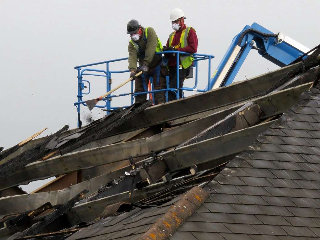 Workmen start removing the fire-damaged roof of the Tesco Express in Mace Lane, Ashford Picture courtesy: Andy Clark