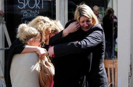 Shop workers comfort each other after stabbing at hairdressers' in Ashford.
