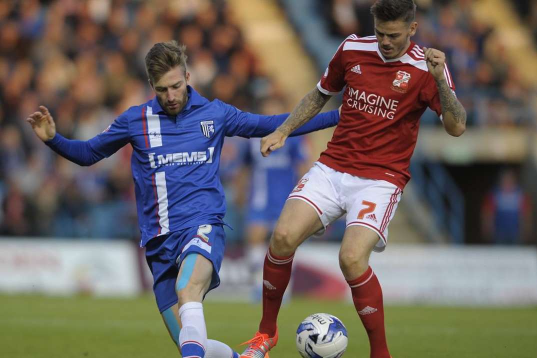 Matt Fish attempts to win back possession for Gillingham against Swindon in August. Picture: Barry Goodwin