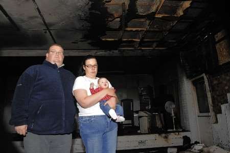 Jamie and Hazel Parker and daughter Megan in the fire damaged St Johns Hall in Church Lane, Canterbury. Picture:Chris Davey