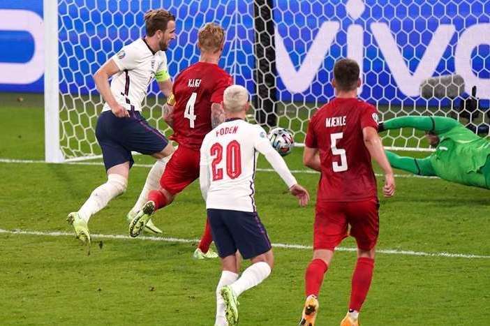 A view of the back of Foden's hairdo, no, sorry, we mean Harry Kane slots home the match winning goal against Denmark. Picture: Mike Egerton/PA
