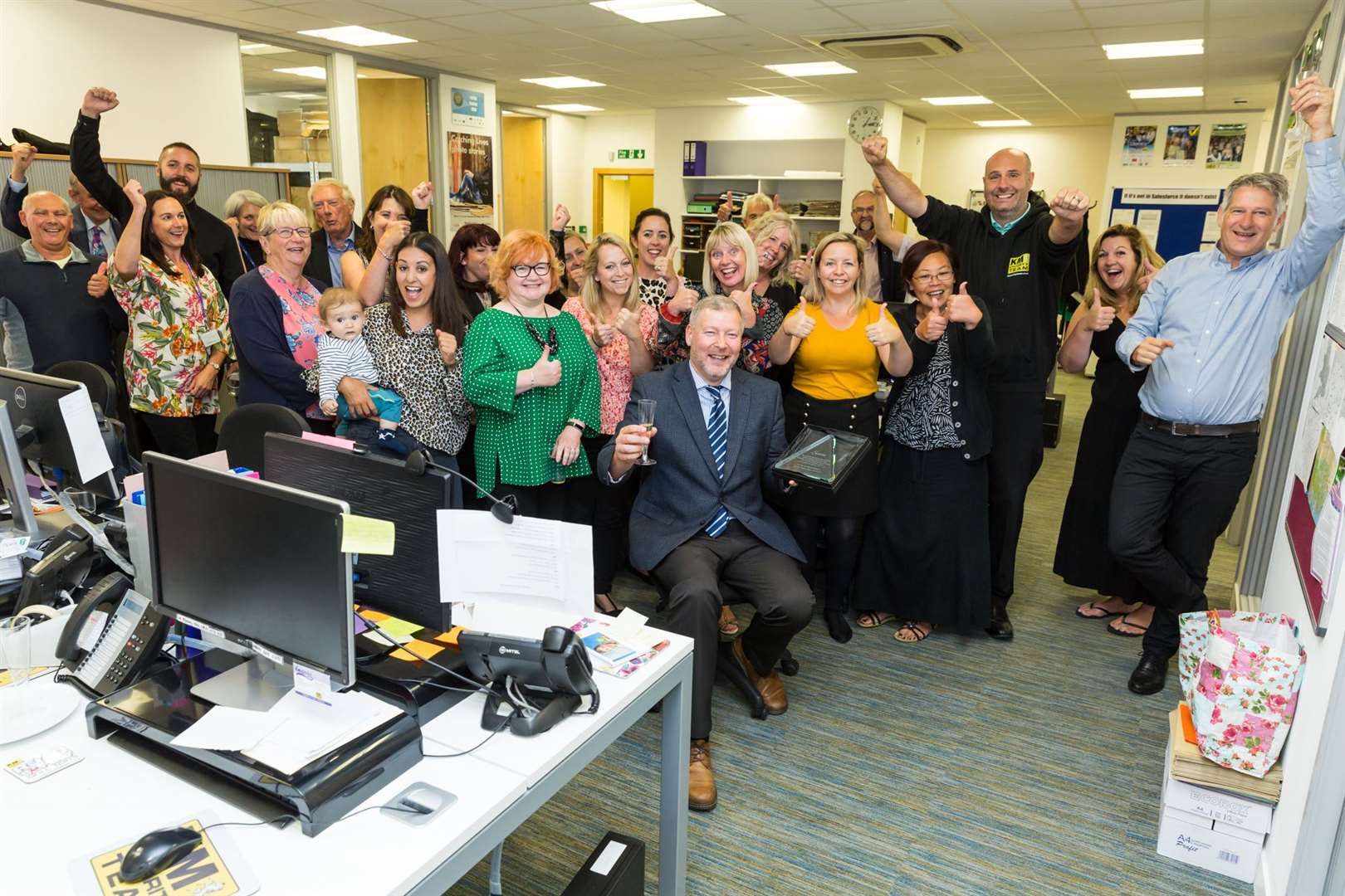Staff and sponsors give outgoing CEO of the KM Charity Team Simon Dolby a rousing send off.