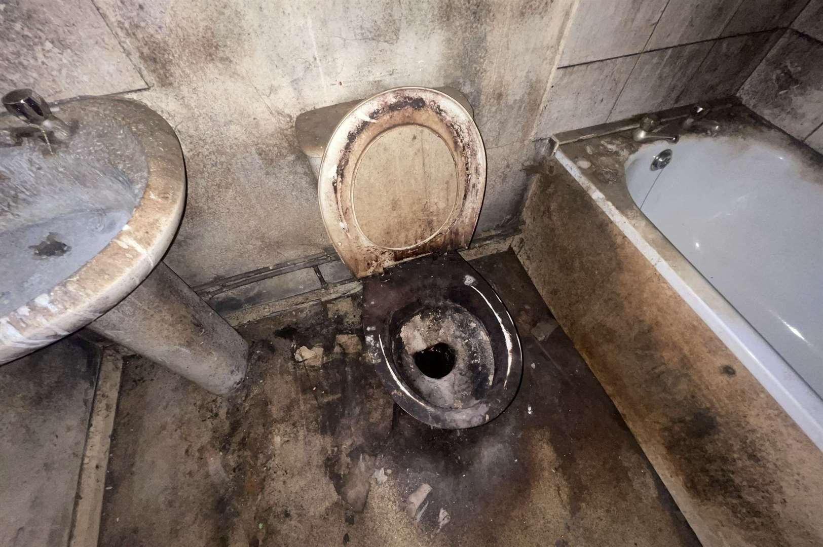 Blackened bathroom inside a filthy property before it received it's first deep clean in twenty years by cleaner couple from Ashford James Kilburn and Kimberley. Photo: SWNS