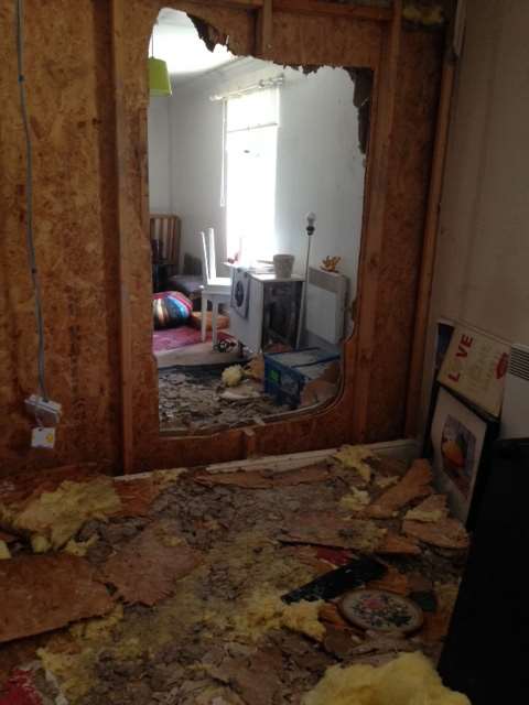 Firefighters smashed this hole in the lounge wall to fight the blaze.