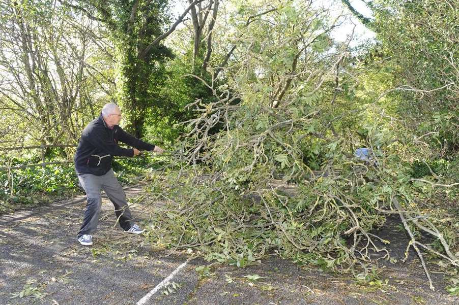 Paul Andrew tries to clear a fallen tree from Military Road in Dover