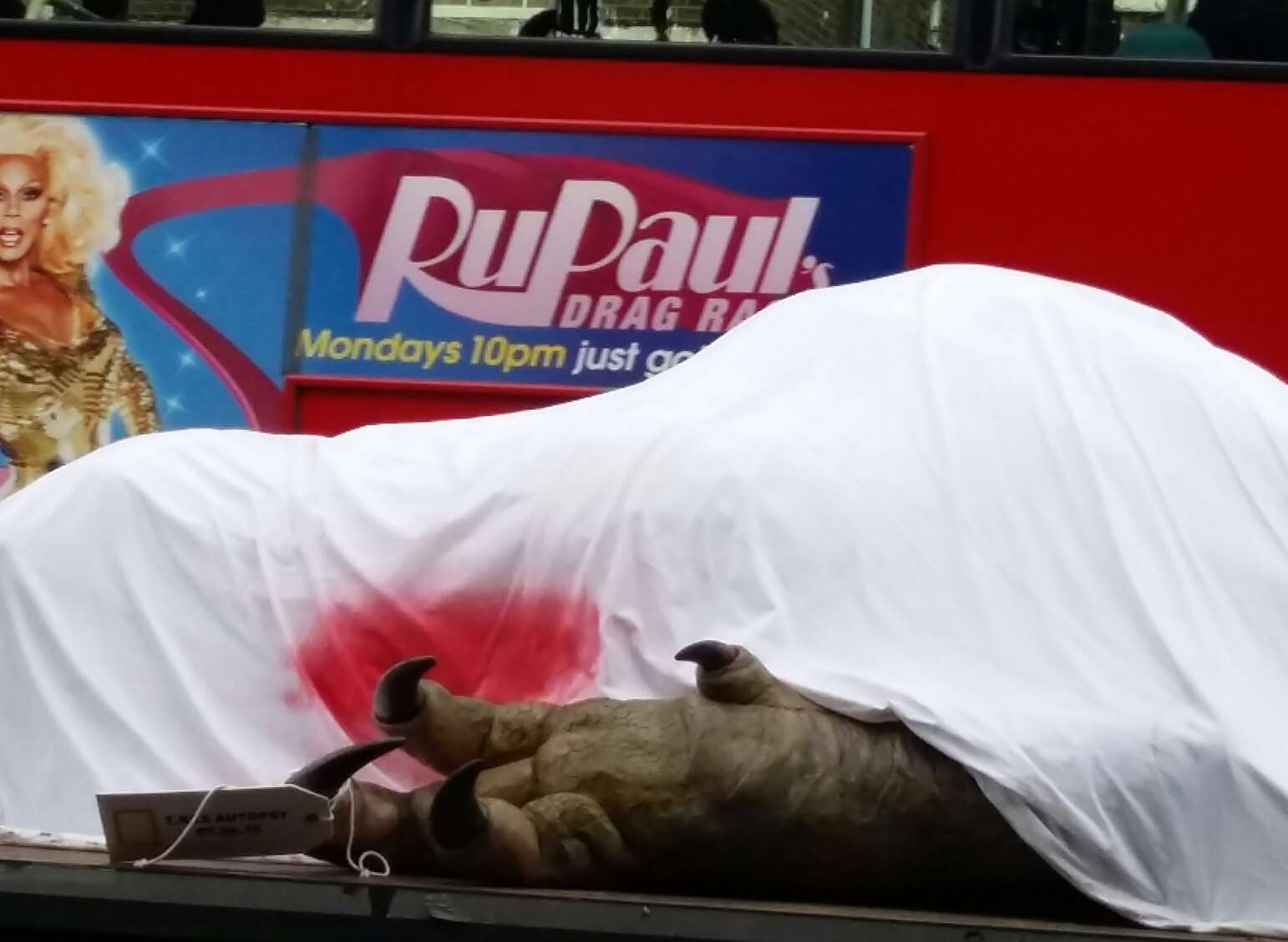The giant dinosaur has been travelling through London covered by a blood-soaked sheet