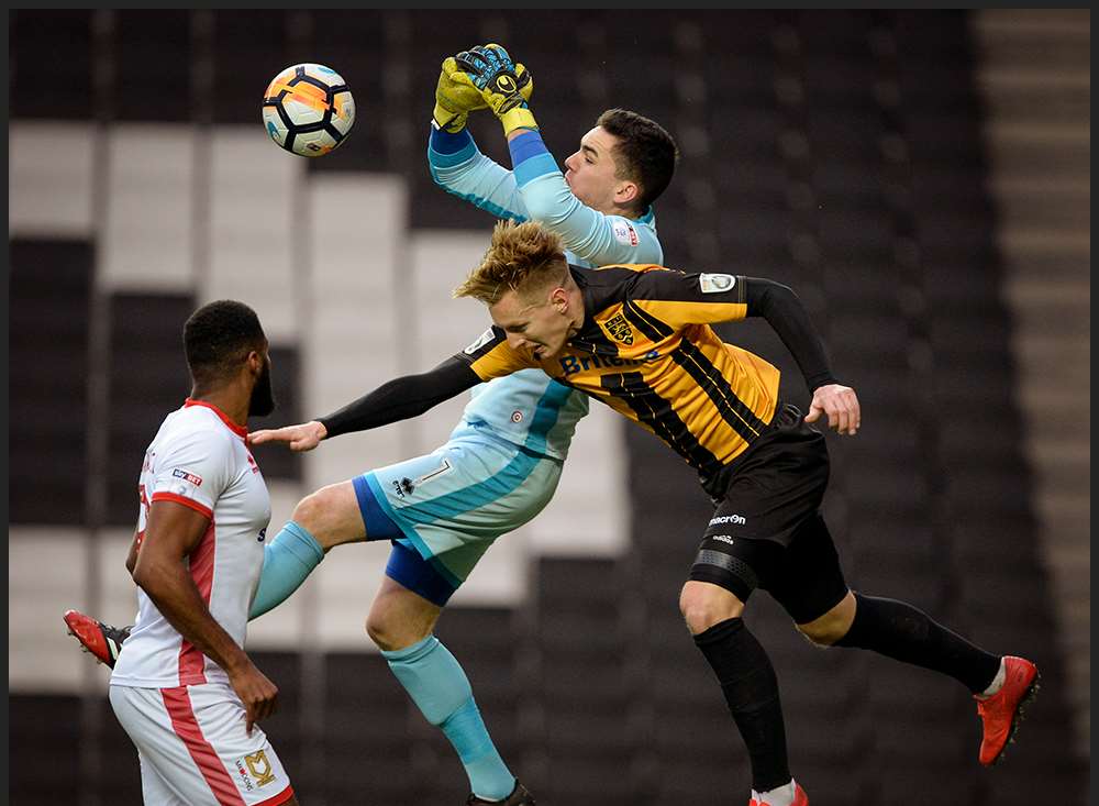 Joe Pigott challenges the Dons keeper Picture: Ady Kerry