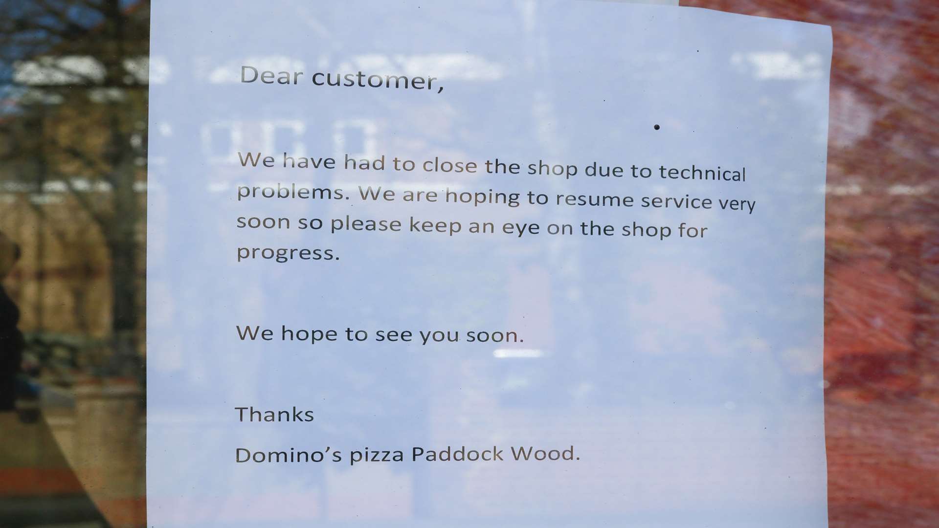The sign being displayed in the store's window