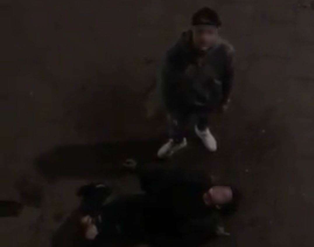 One person is laying on the floor in the video while another confronts the man videoing (8219090)