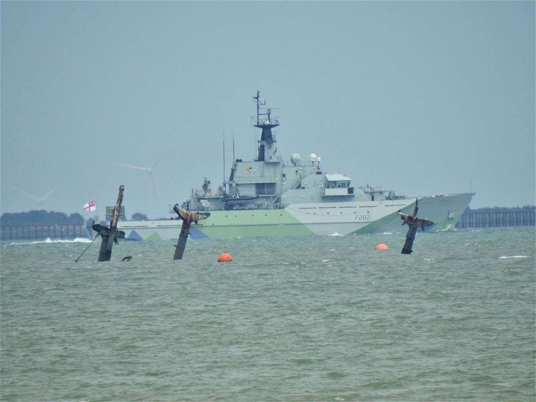 The camouflaged Royal Navy patrol boat HMS Severn passing the wreck of the American bomb ship SS Richard Montgomery off Sheerness after being recommissioned in London. Picture: Adam Young/Swale Weather