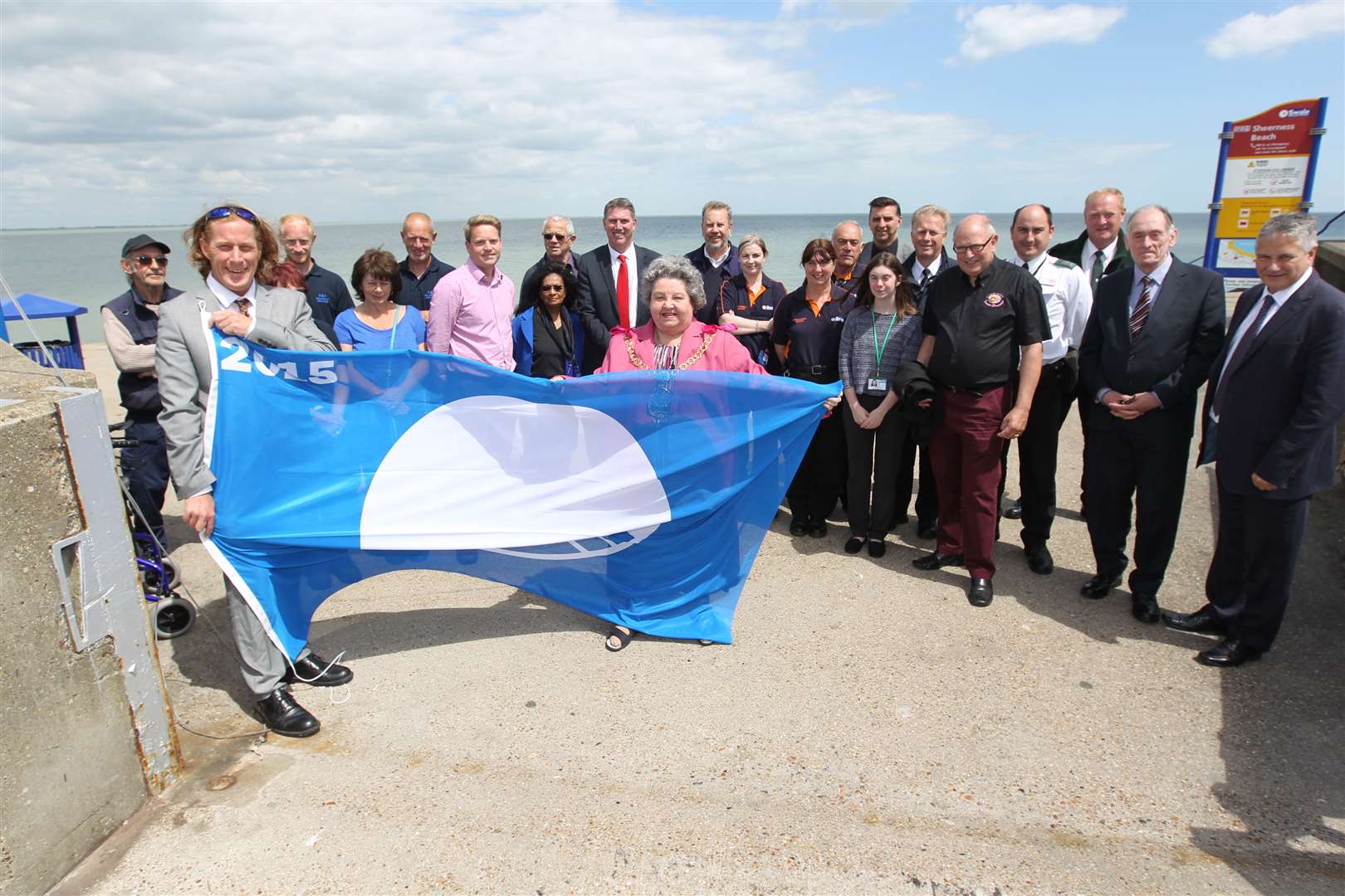 From left, Ian Arnell, Seafront Officer for Swale Borough Council and The Mayor of Swale Cllr Anita Walker, surrounded by environmental officers, councillors and other local people, hold a blue flag which symbolises a clean beach at the start of summer