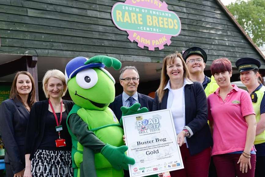 Certificate presentation ceremony to promote road safety skill tests. From left: teacher Amy Woods, Sarah Leipnik (Golding Homes), Buster Bug (KM Walk to School mascot), Clive Perry (Specsavers Ashford), Elizabeth Carr (Bell UK), Sarah Kirk (Rare Breeds Centre) and David Brown and Gayna Murphy, Civil Enforcement officers