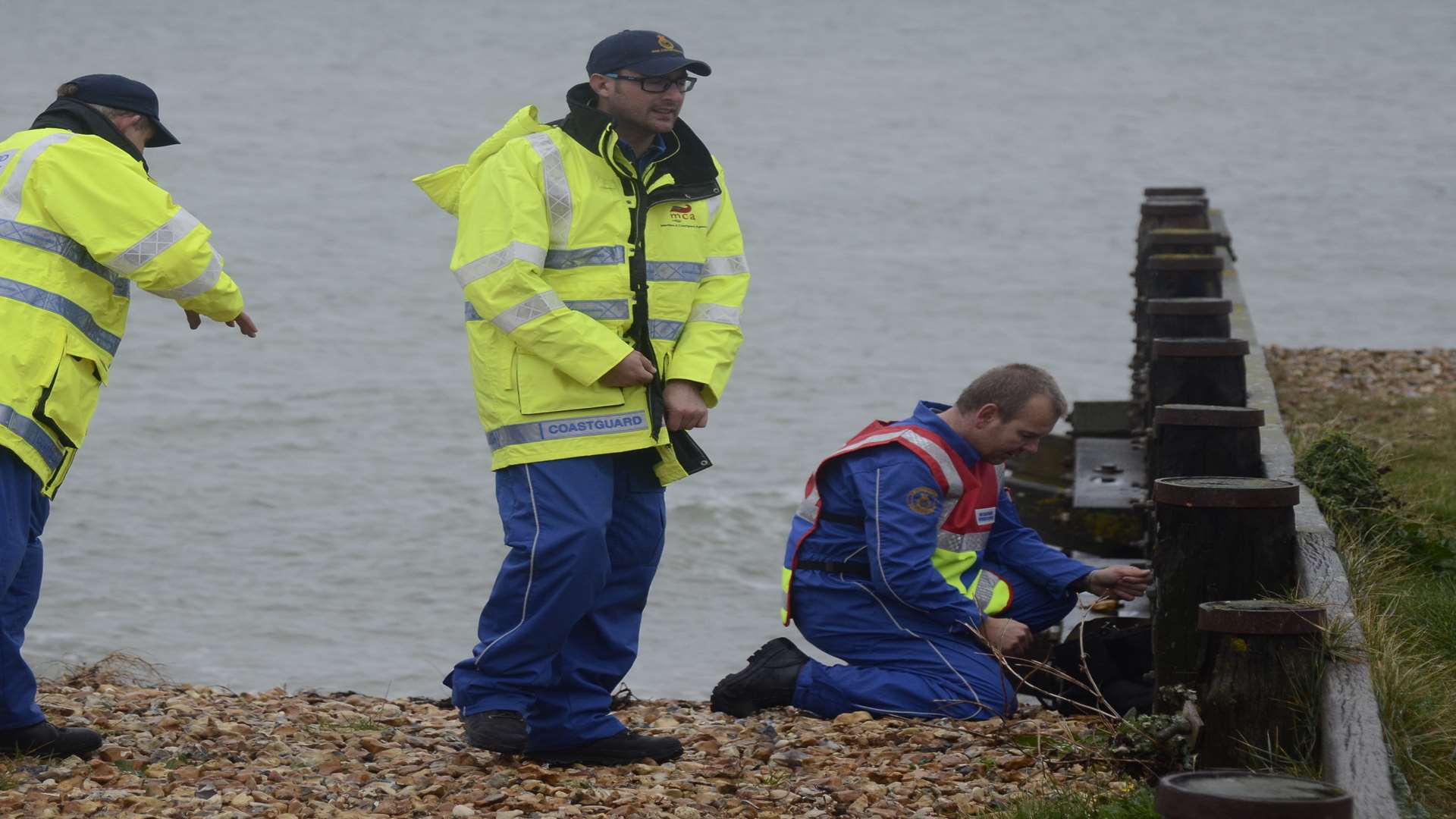 Coastguard teams inspect items of clothing found on the beach. Picture: Chris Davey