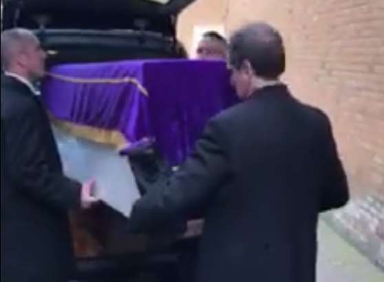 The 'coffin' is removed from the hearse