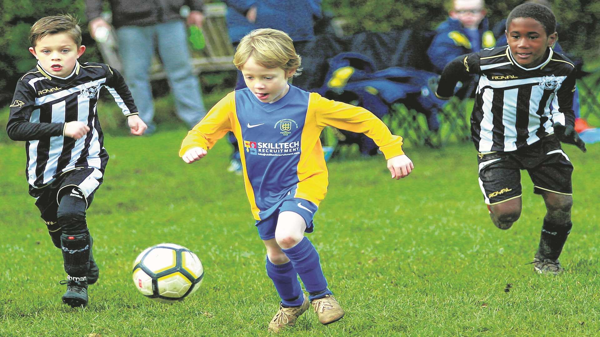 Sheerness East under-7s (yellow) take the game to Milton & Fulston under-11s Picture: Phil Lee