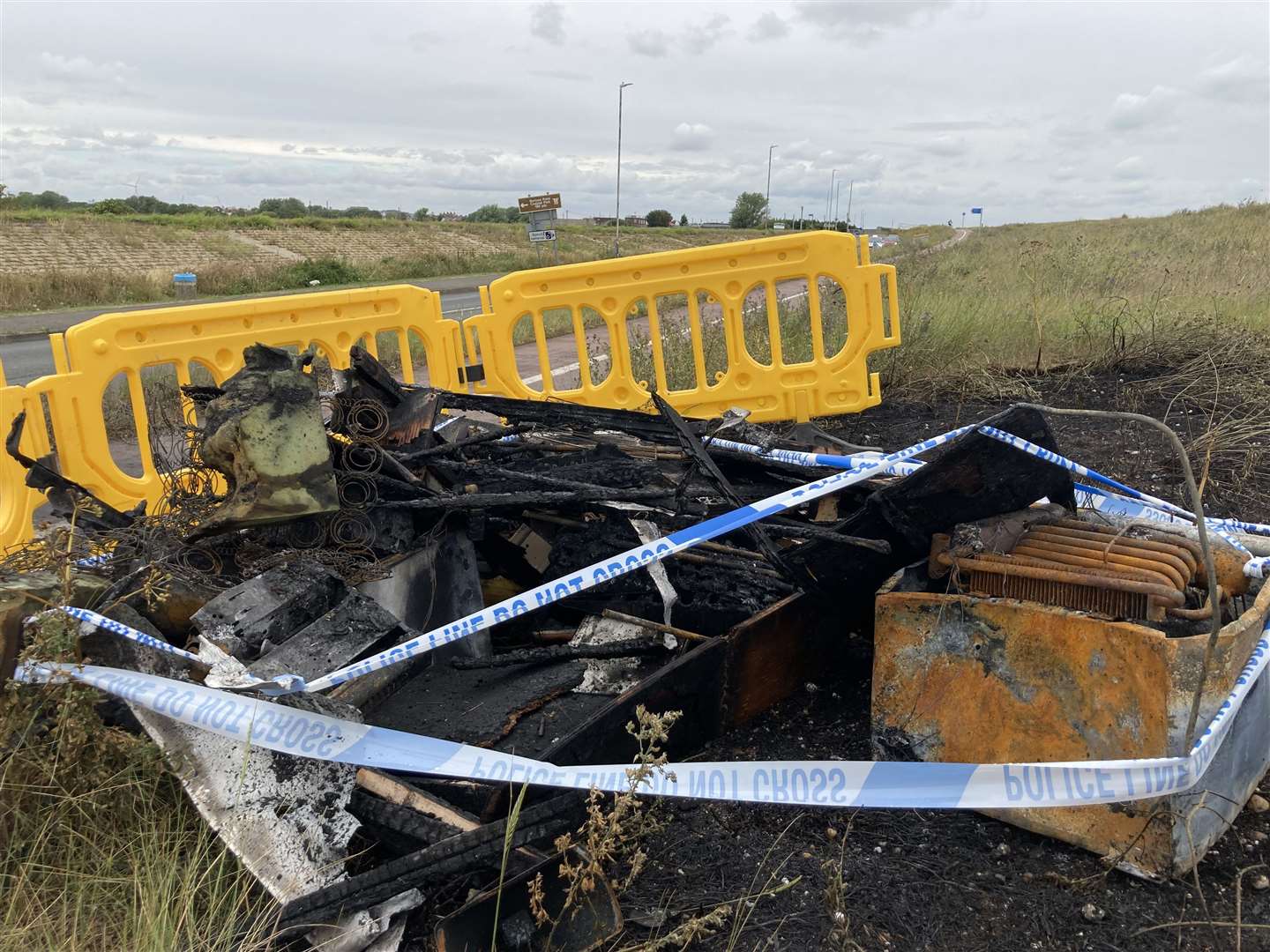 Police tape cordons off the remains of a motor home which caught fire
