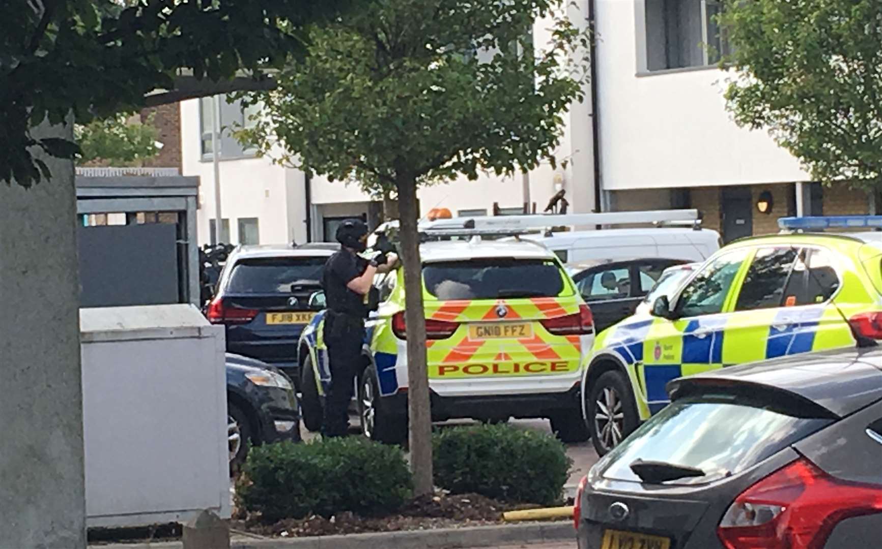 An officer has been seen pointing a gun at a block of flats
