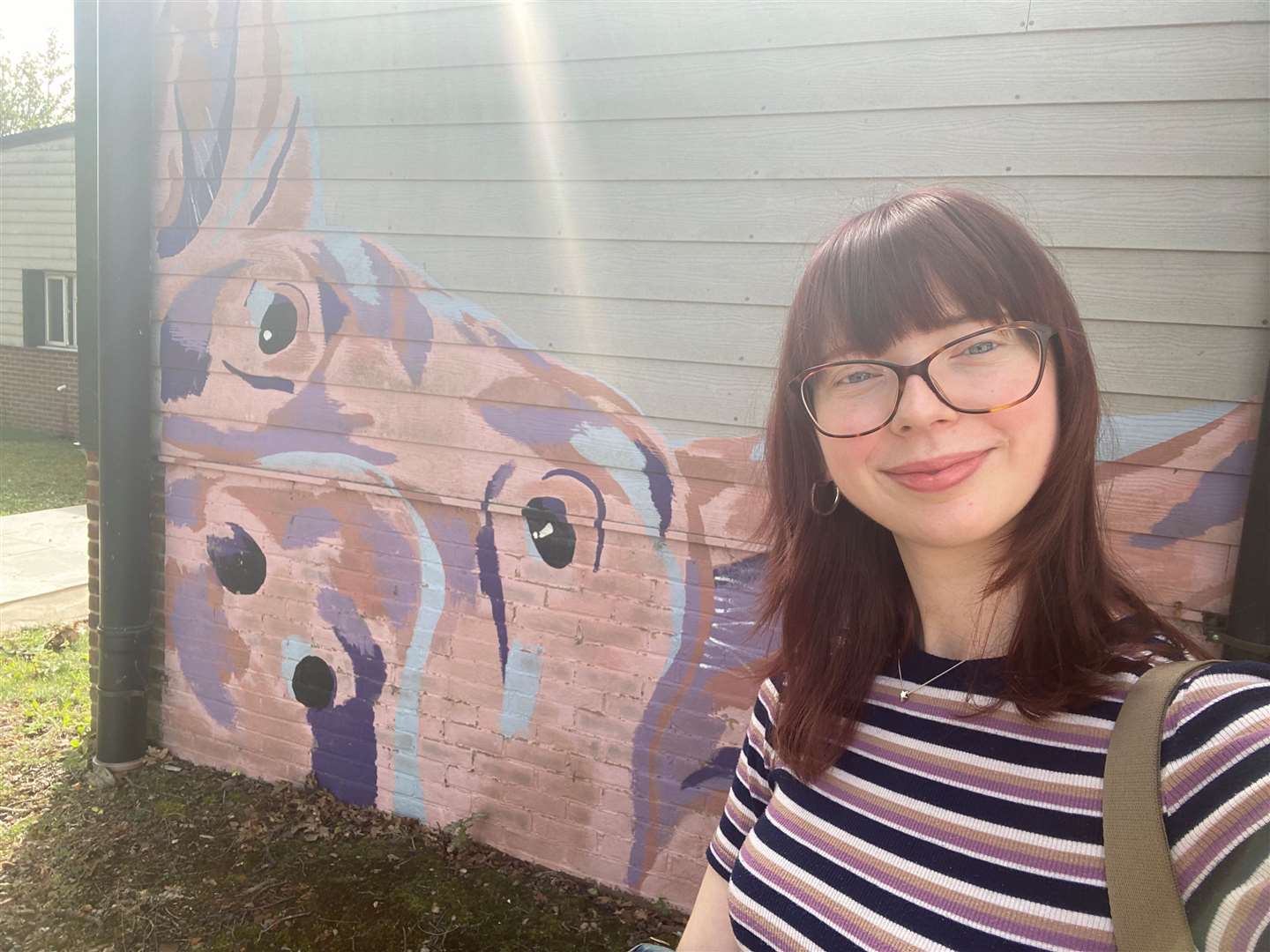 Reporter Cara Simmonds next to the pig mural