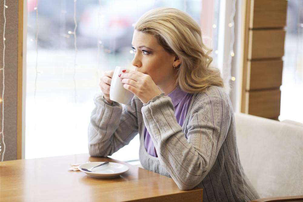 Woman drinking coffee. Library image.