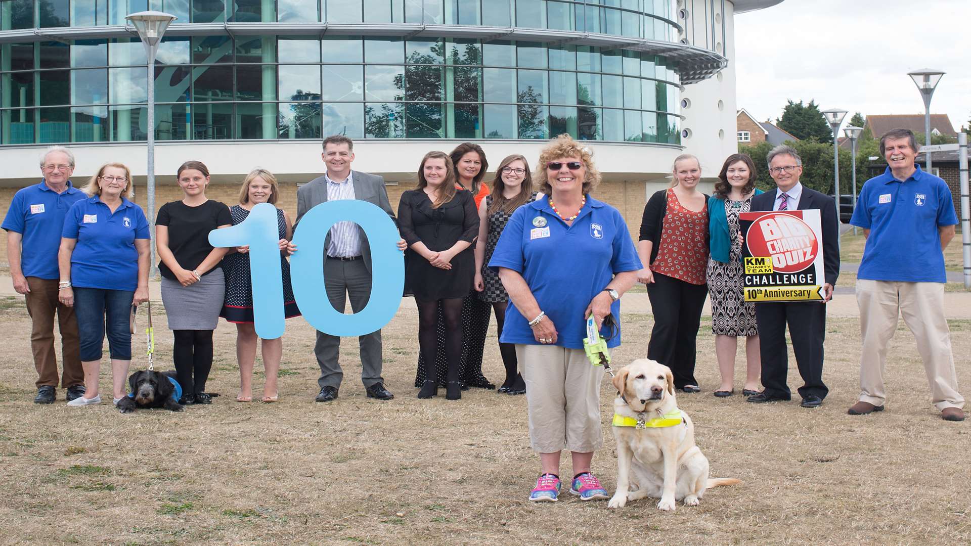 Pat Marshall (front) with guide dog Chloe and partners of the 10th anniversary KM Big Quiz HR GO, Hallett and Co and Specsavers.