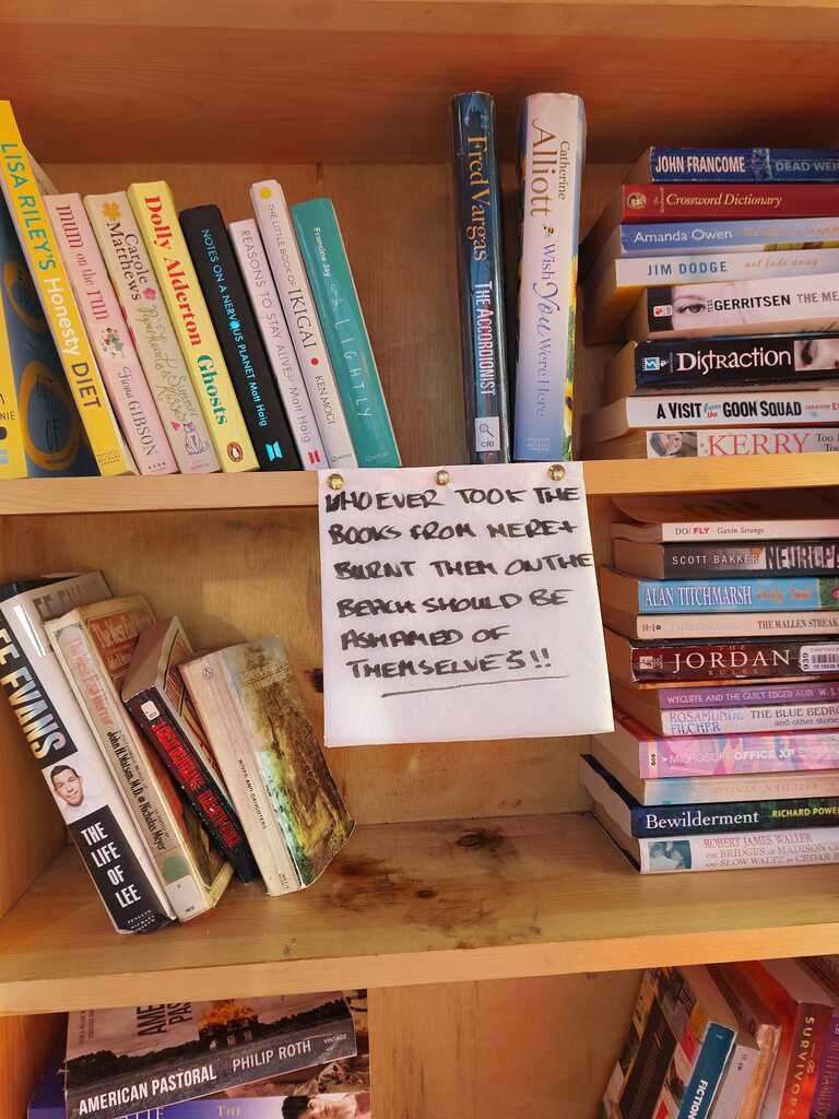 A sign left in the library after the books were stolen and burnt. Picture: Jacqueline Browning