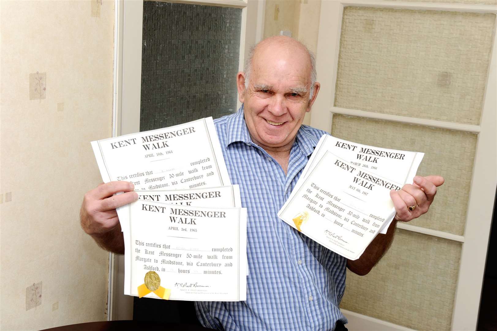 Brian in 2013, the 50th anniversary of the first KM walk, with the certificates he received for completing all five walks. Picture: Simon Hildrew