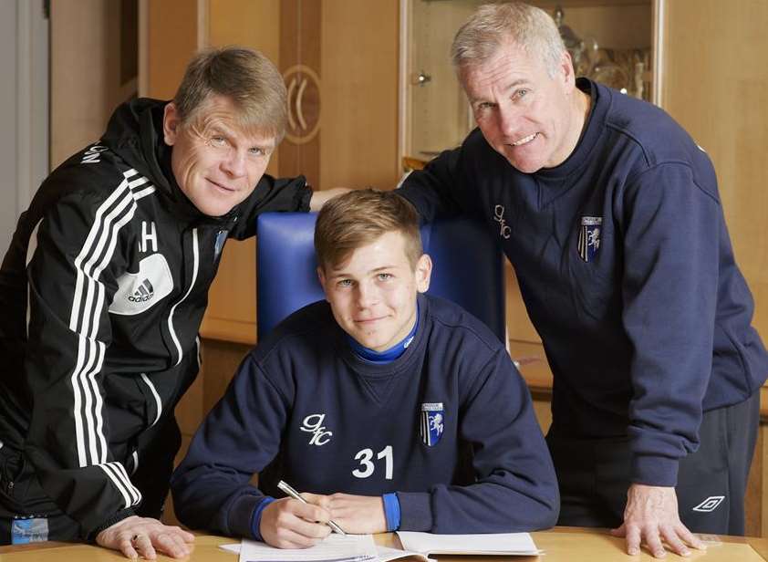 Jake Hessenthaler, watched by father Andy and manager Peter Taylor, signs a new Gills contract. Picture: Andy Payton