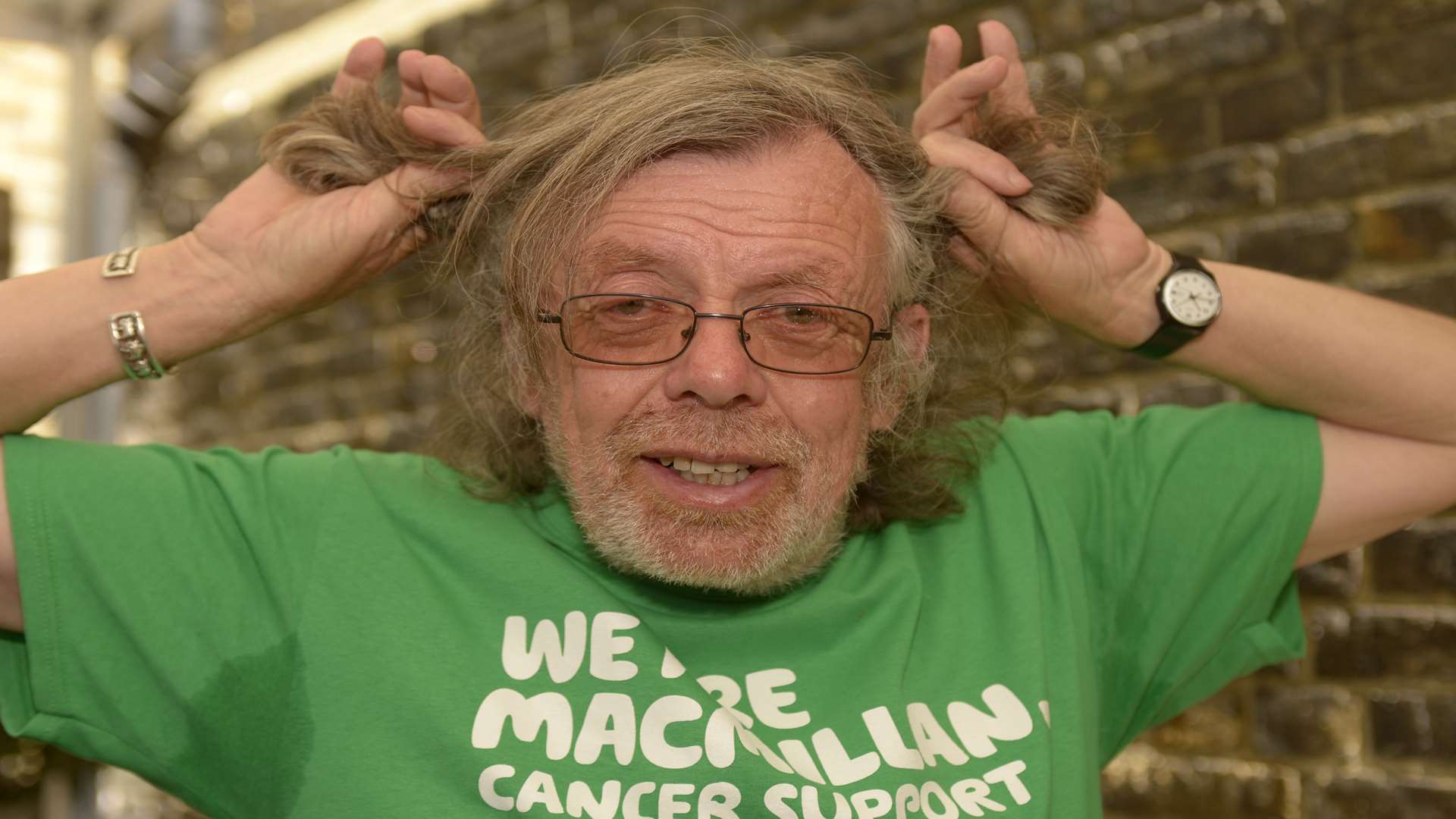 Artist Bob Lamoon having his hair chopped in the middle of the town centre to raise money for Macmillan Cancer Support.