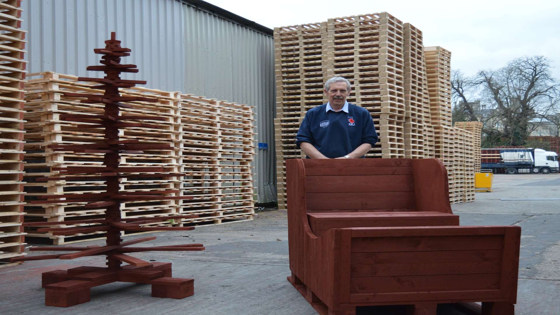 Nigel Chambers helped construct Santa's sleigh from used pallets. Here he is pictured with the sleigh and the tree he created