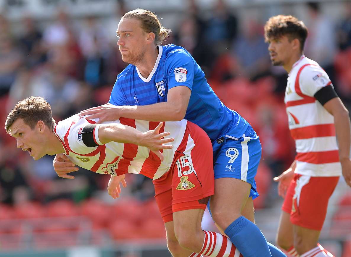 Gillingham striker Tom Eaves up against Doncaster's Joe Wright Picture: Ady Kerry