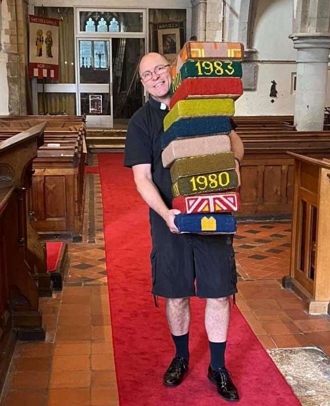 Father Robert Lane takes away the 'kneelers' at the church