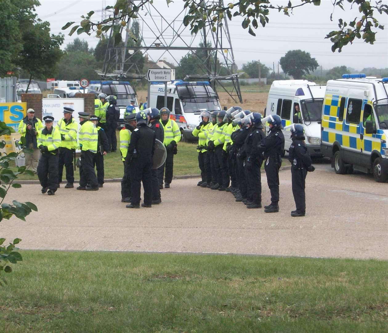 Riot police prepare to tackle a sit down protest by climate change campaigners at the gates of Kingsnorth power station