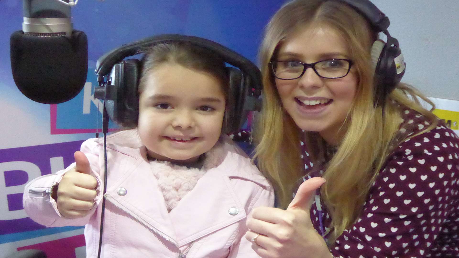 Ruby Godla, seven, of St Augustine's of Canterbury Primary School, is welcomed as the new boss for KMFM for a day by breakfast show presenter Laura Nevitt.