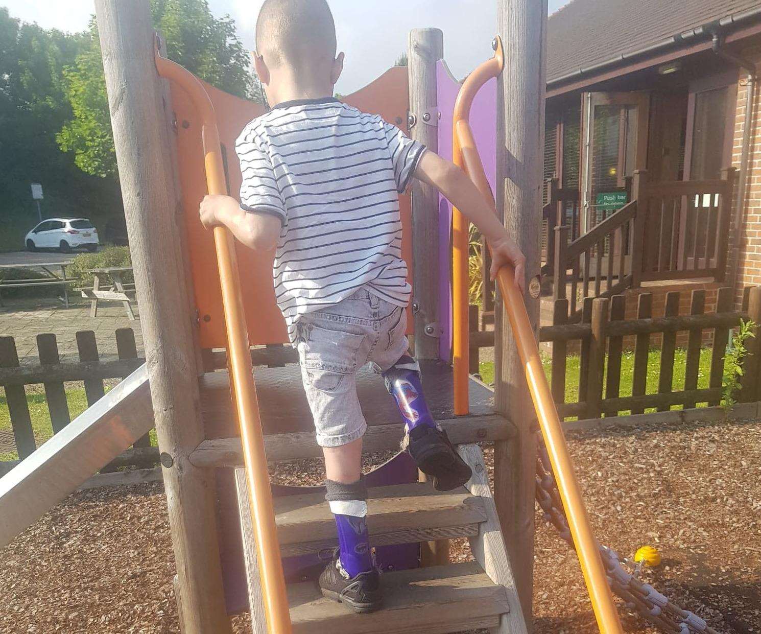 Theo Knott conquers the steps up the slide following his surgery