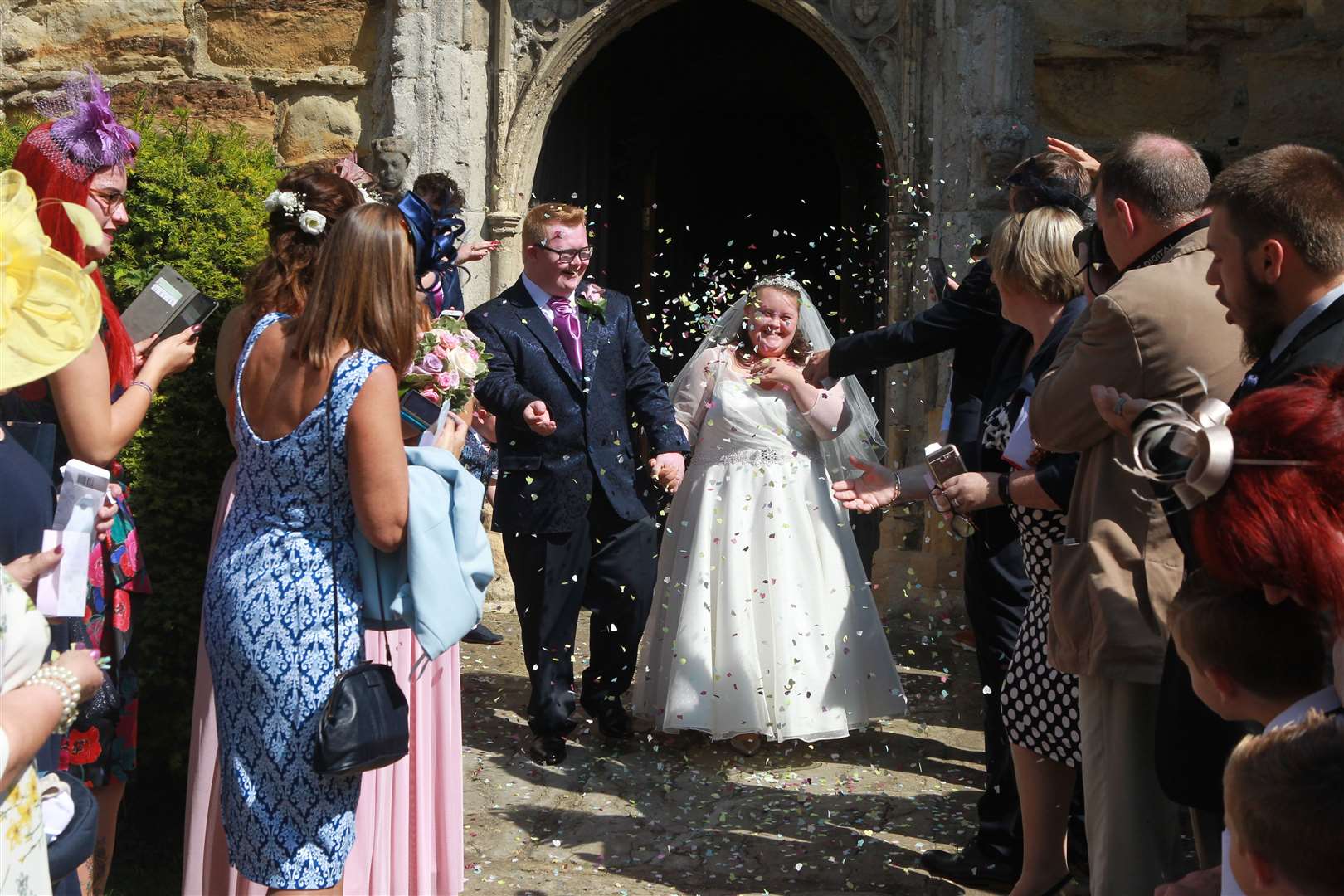 Kieran Duffy and Emma Houckham, emerge from All Saints Church, for the traditional throwing of confetti in Staplehurst. Picture: John Westhrop