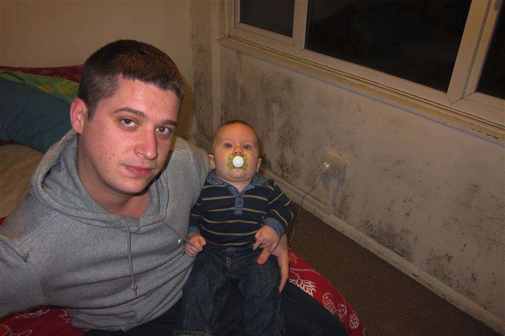 Paul Walton with baby son Archie in their mouldy flat