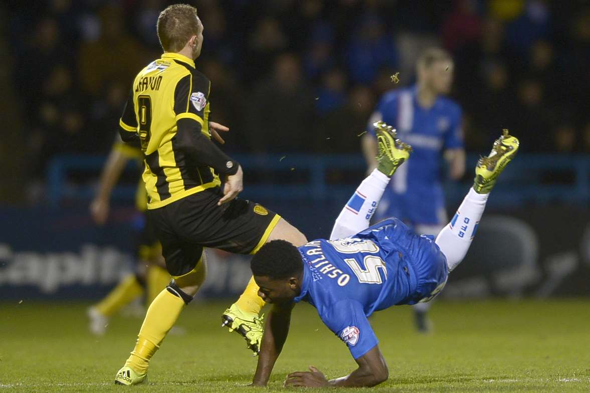 Deji Oshilaja and Gills tumble against Burton at Priestfield Picture: Barry Goodwin