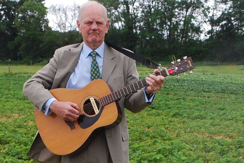 Posing with a guitar, Martin Clews on his strawberry farm in Seal