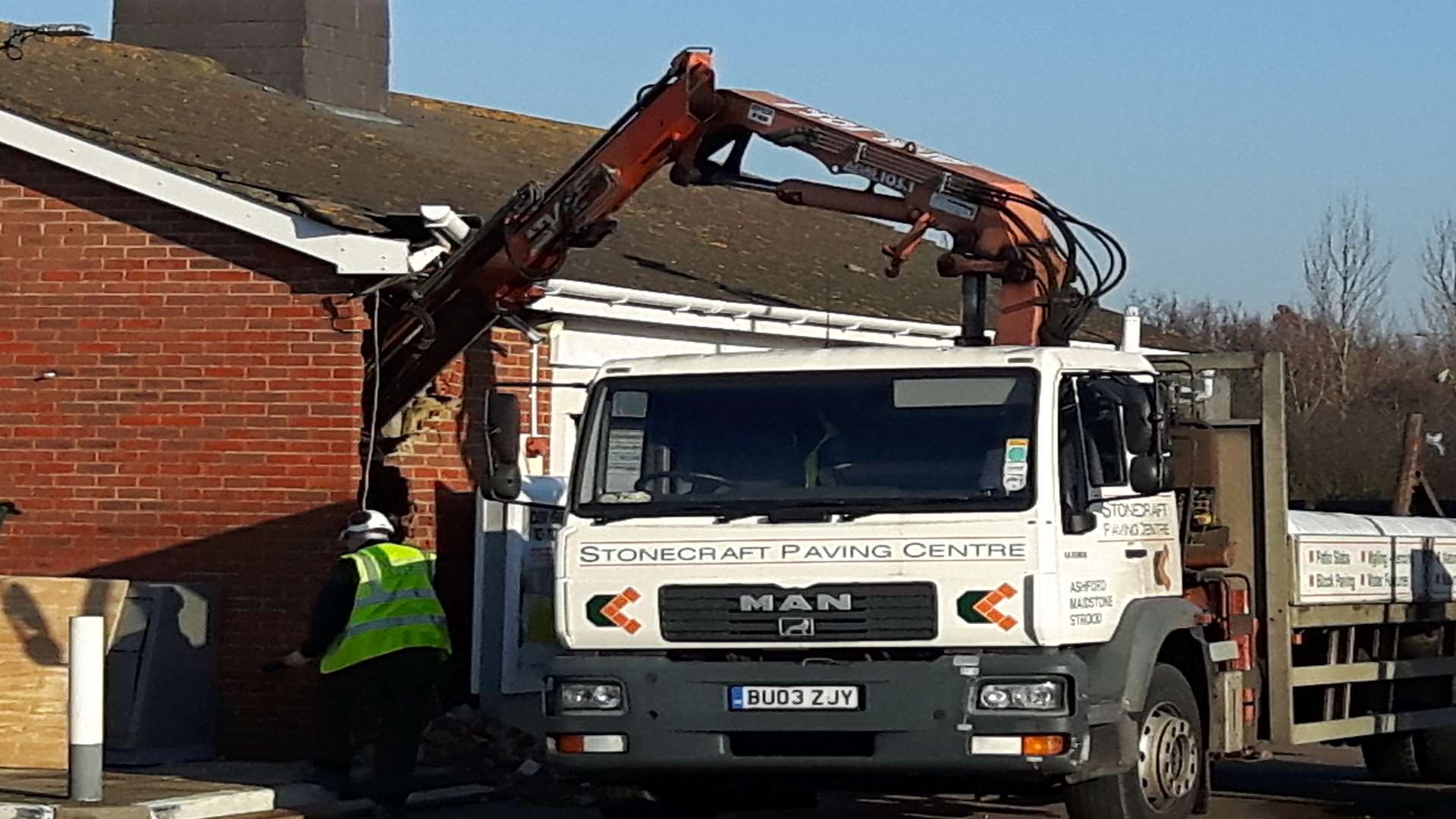 A crane was used to smash a hole in a brick wall