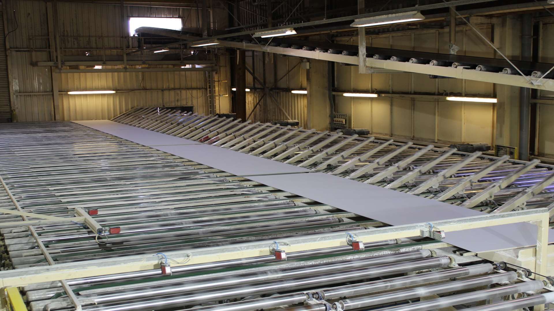 Sheets of cut plasterboard are automatically flipped in a u-turn at the end of the quarter-mile production line