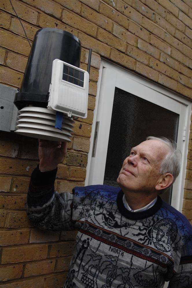 Jeremy Procter inspects his weather monitoring equipment outside his home