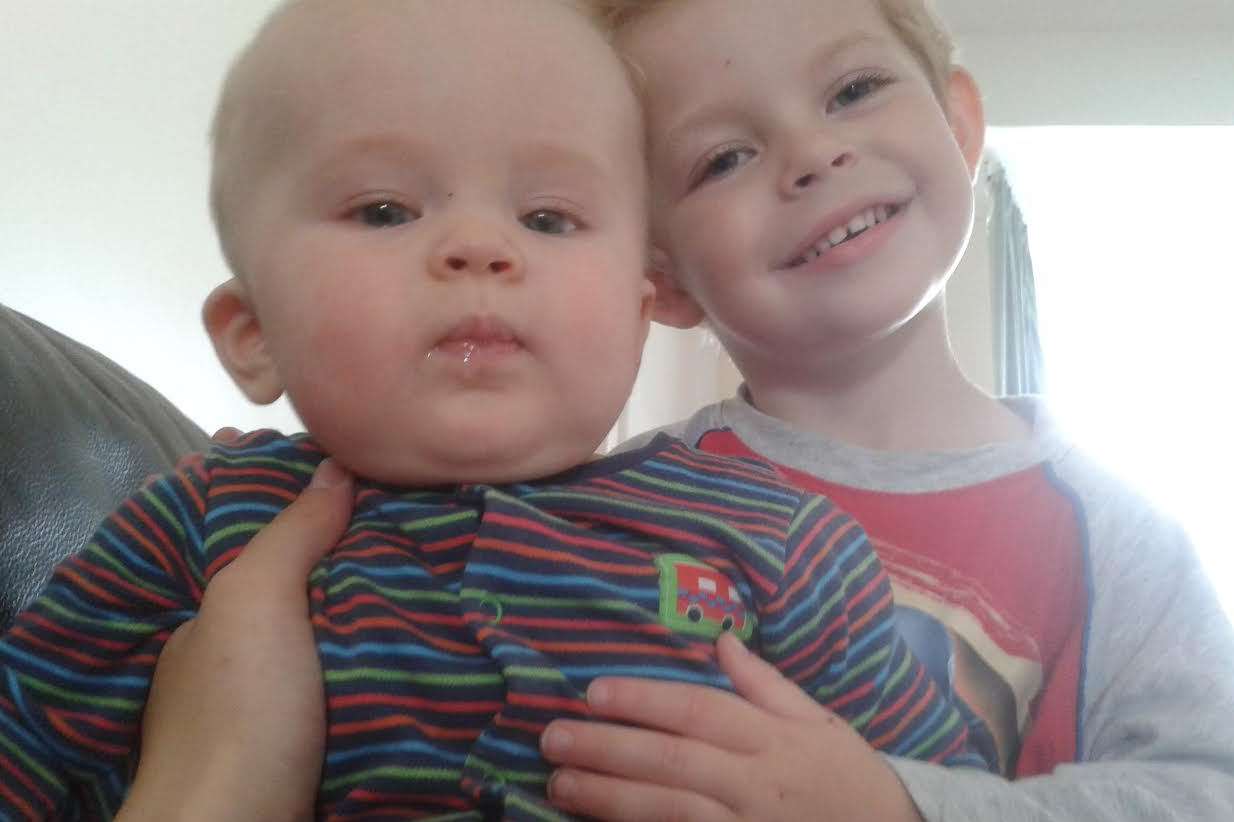 Big brother Lucas, now three, gives Owen a Christmas hug