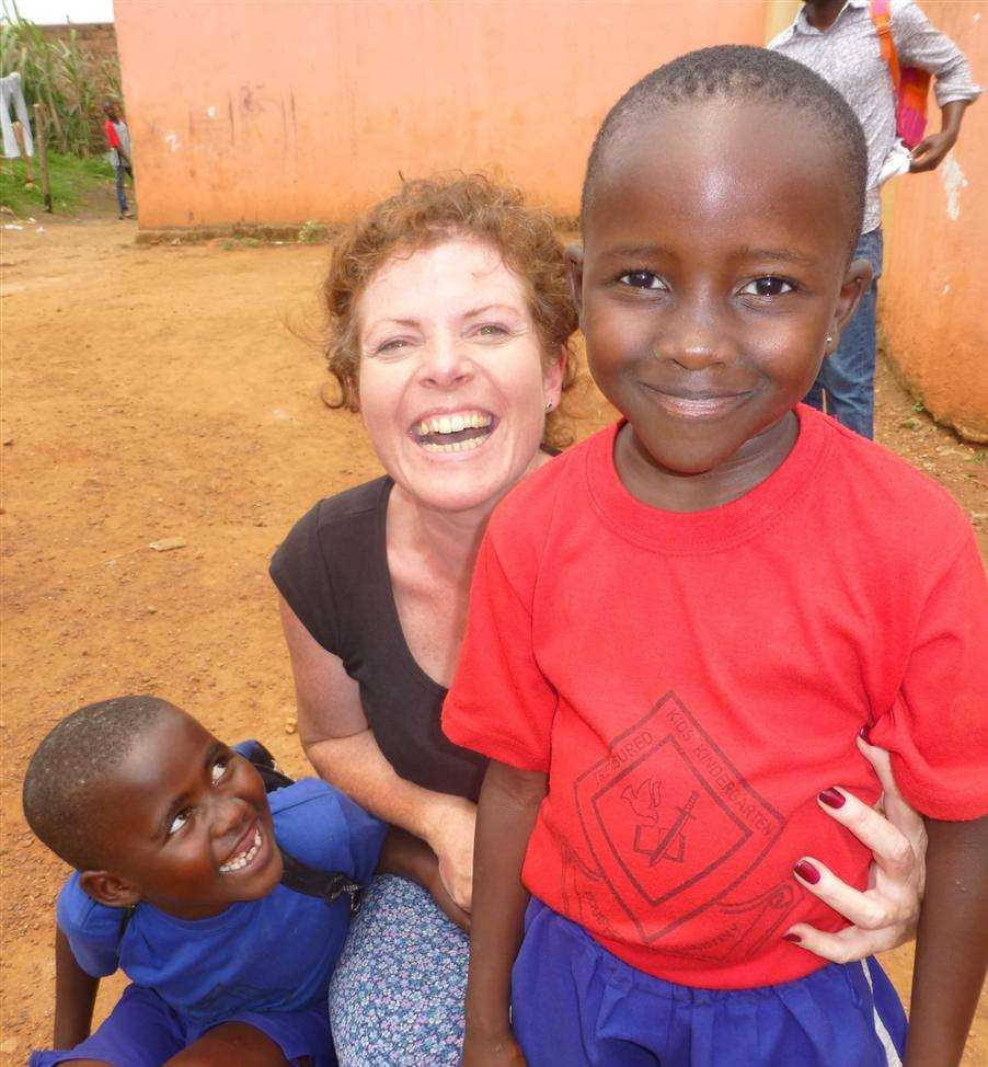 Debbie's grin is matched by the young Ugandans' smiley faces